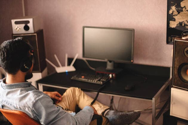 Young man listening music sitting by desktop computer at home ,model released, Symbolfoto CR_DMBE200120-269134-01
