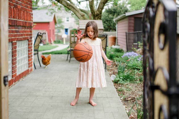 A girl stands with basketball mid-dribble with chicken behind her Columbus, OH, United States ,model released, Symbolfoto ,editorial use only CR_RETI200120A-250633-01