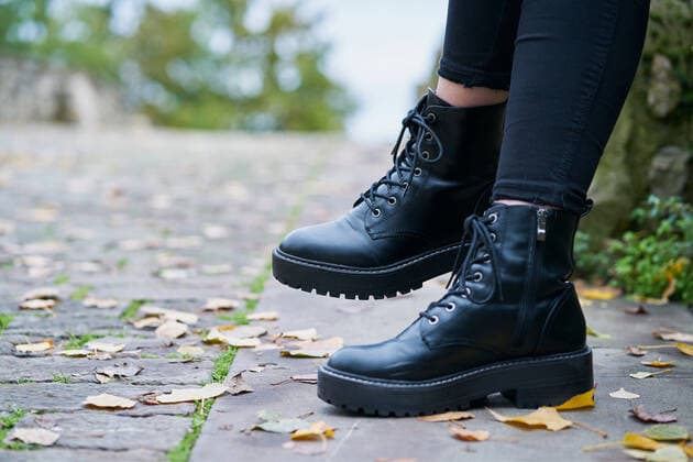 IMAGO Creative, Jahreszeit Herbst, Ferien Close-up of the boots worn by a woman in military style in black with a stone floor background Pamplona, Navarre, Spain ,model released, Symbolfoto CR_SEBO200124B-290060-01
