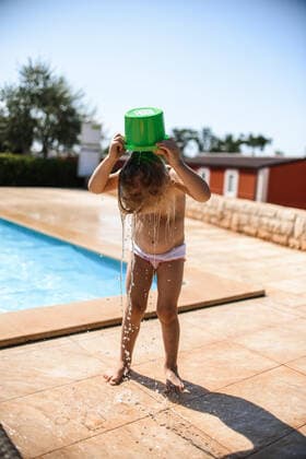Little girl swimming in the pool. Watering herself from a bucket Horvati, City of Zagreb, Croatia ,model released, Symbolfoto CR_YUKI200203C-229619-01
