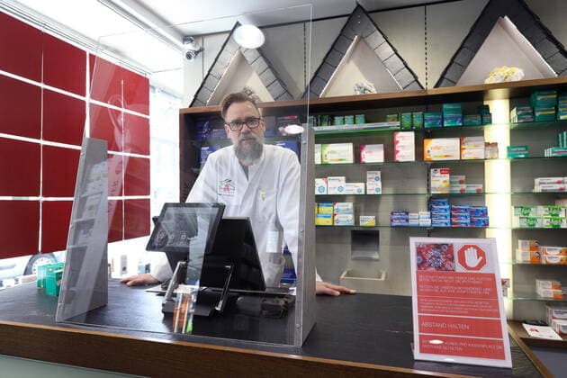 The owner of Glueckauf Apotheke Henning Schweisfurth has had walls made of glass so that employees and customers cannot cough and sneeze on them directly. Such protection can be found at every place on the service counter with a symbolic picture on the subject of coronavirus on 16 03 2020 in Siegen Germany