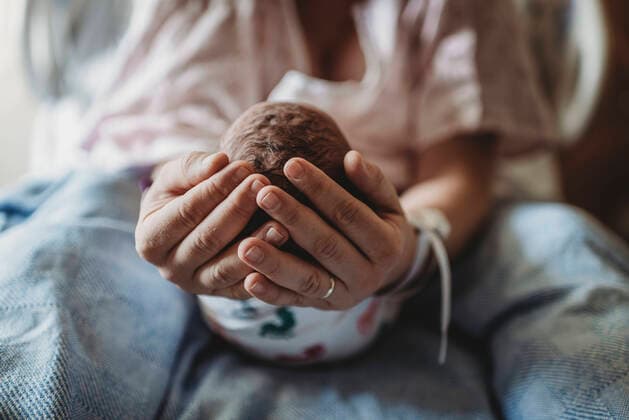 Macro view of mothers hands holding newborn boy s head San Diego, CA, United States ,model released, Symbolfoto CR_KESM200220-261003-01