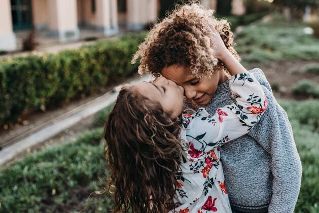 Twin brother kissing sisters cheek while standing outside at park San Diego, CA, United States ,model released, Symbolfoto CR_KESM200224-295613-01