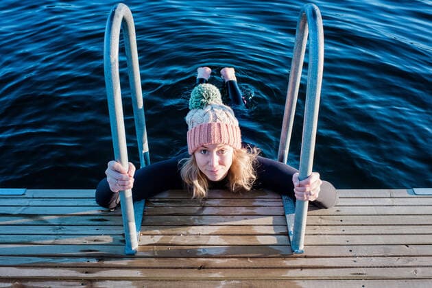 IMAGO Creative: Alternativer Wintersport woman looking up holding onto steps whilst cold water ice swimming NorrtoÂ¤lje, Stockholm County, Sweden ,model released, Symbolfoto CR_RABE200224-308750-01