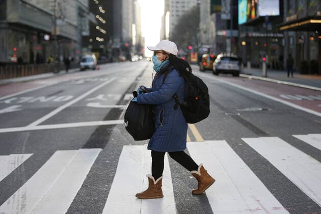 A woman wearing a face mask crosses 42nd street surrounded by almost no pedestrian and automobile traffic the morning rush hours in Times Square in New York City on Wednesday, March 18, 2020. The federal government is working on a $1 trillion coronavirus stimulus package to try and rescue the U.S. economy from the coronavirus pandemic.  NYP20200318127 JOHNxANGELILLO