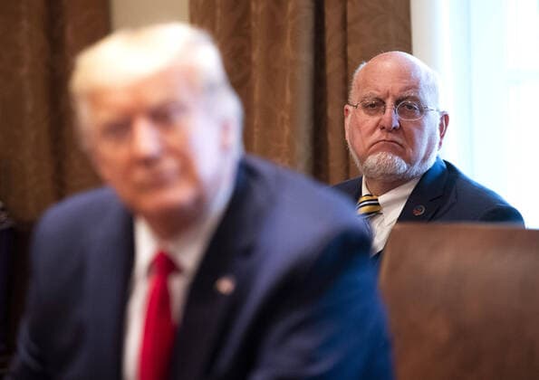 CDC Director Robert R. Redfield (L) listens as President Donald Trump speaks to reporters as he holds a meeting with nurses on the COVID-19 response at the White House in Washington, DC, March 18, 2020, in Washington, D.C. Photo Kevin Dietsch  WAP20200318334 KEVINxDIETSCH