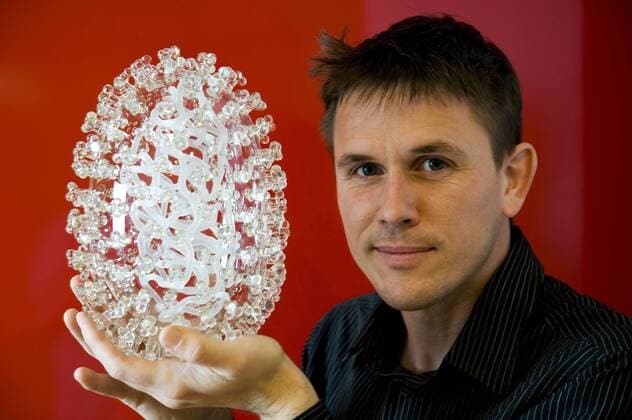 March 19, 2020, Bristol, United Kingdom: IN PHOTO: Artist Luke Jerram with a glass sculpture of the Swine Flu virus..Internationally-renowned British artist Luke Jerram has created a coronavirus glass sculpture in tribute to the huge global scientific and medical effort to combat the pandemic...Made in glass, at 23cm in diameter, it is 1 million times larger than the actual virus. ..It was commissioned 5 weeks ago by a university in America to reflect its current and future research and learning in health, the environment and intelligent systems, and its focus on solving global challenges. ..Luke says: Ã¢â‚¬oeHelping to communicate the form of the virus to the public, the artwork has been created as an alternative representation to the artificially coloured imagery received through the media. In fact, viruses have no colour as they are s - ZUMAc218 20200319_zia_c218_020 Copyright: xWellcomexImagesx