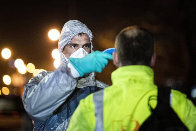 A man in a protective suit checks the body temperature of travellers entering the country at the German-Polish border in Goerlitz, 19 03 2020 In the night of 14 03 to 15 03 the borders between Germany and Poland and the Czech Republic were closed to contain the spread of corona virus Goerlitz Germany Copyright: xFlorianxGaertner photothek.netx