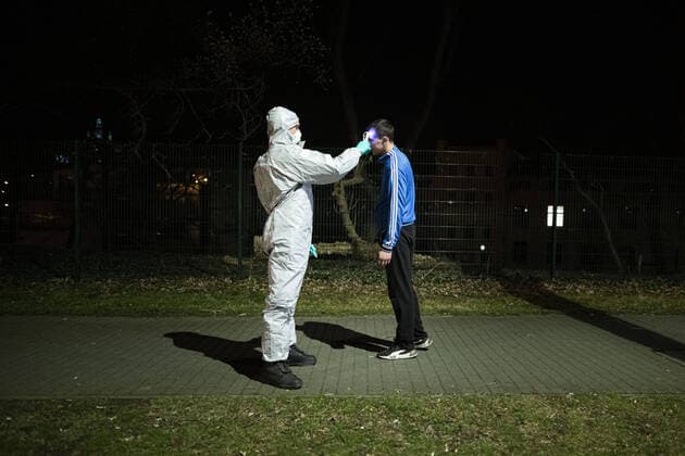 A man in a protective suit checks the body temperature of travellers entering the country at the German-Polish border in Goerlitz, 19 03 2020 In the night of 14 03 to 15 03 the borders between Germany and Poland and the Czech Republic were closed to contain the spread of corona virus Goerlitz Germany Copyright: xFlorianxGaertner photothek.netx