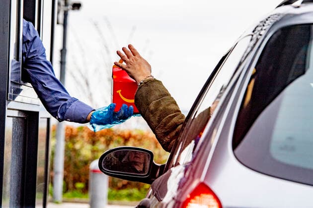 March 18, 2020, Schiphol, Netherlands: An employee wearing gloves as a protection seen giving food to a costumer at a McDonald s Mac Drive amid Coronavirus (Covid-19) fear..Netherlands™s Health Ministry recorded a total of 2,460 infections, 76 death and 2 recovered since the beginning of the outbreak. Schiphol Netherlands - ZUMAs197 20200318_zaa_s197_242 Copyright: xRobinxUtrechtx