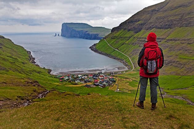 Eine Wandererin schaut auf den kleinen Ort Torshavn und den Atlantik, Faeroeer, Streymoy, Torshavn walker looking down onto the small village Torshavn and the Atlantic Ocean, Faroe Islands, Streymoy, Torshavn BLWS610494 Copyright: xblickwinkel S.xZiesex
