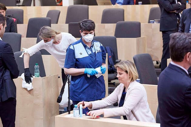 - Wien 20.03.2020 - Parlament Nationalrat Sondersitzung zum Coronavirus - Während der zweiten Sondersitzung innerhalb einer Woche wurden u.a. die im Eiltempo entworfenen Gesetze zur Bekämpfung der Pandemie sowie der wirtschaftlichen Folgen vom österreichischen Parlament beschlossen. Während der Sitzung wurde ein positiver Coronafall unter den Abgeordneten bekannt die Sitzung wurde für eine Stehpräsidiale unterbrochen um danach ganz unterbrochen zu werden für Gespräche in den jeweiligen Parteiklubs. PHOTO: Während der Unterbrechung wurde der gesamte Plenarsaal von einer Putzkolonne desinfiziert, hier räumt die NEOS-Parteichefin dafür ihren Sitzplatz. Vienna (AUSTRIA) - Parliament National Council special session on the corona virus - During the second special session within a week, the laws drafted to combat the pandemic and the e 
