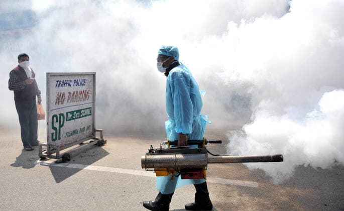 (200320) -- JAMMU, March 20, 2020 -- A health worker disinfects a closed market after authorities ordered the closure of all shops except pharmacies and grocery stores in Jammu, Indian-controlled Kashmir, March 20, 2020. (Str Xinhua) KASHMIR-JAMMU-COVID-19 Stringer 
