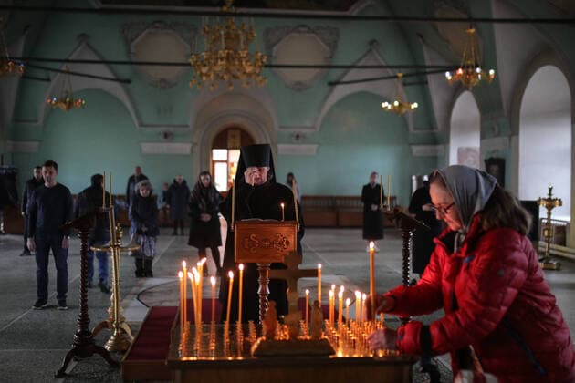 MOSCOW, RUSSIA - MARCH 20, 2020: A priest and believers during an evening service at the Vysokopetrovsky Monastery. Starting from March 18 monks conduct a religious procession and spray holy water after the evening service at the monastery amid the coronavirus pandemic. Sergei Bobylev TASS  TS0D2ED4