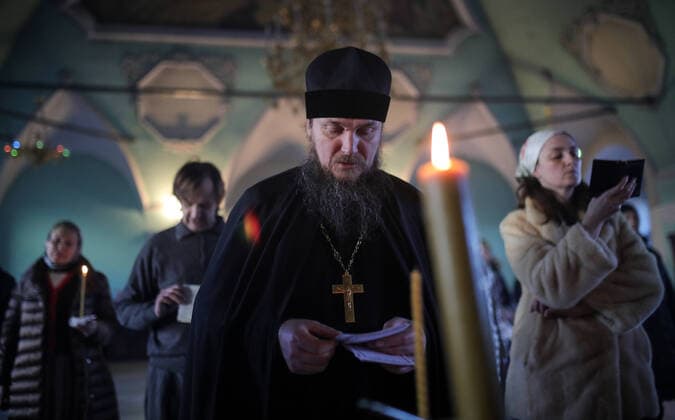 MOSCOW, RUSSIA - MARCH 20, 2020: A priest and believers during an evening service at the Vysokopetrovsky Monastery. Starting from March 18 monks conduct a religious procession and spray holy water after the evening service at the monastery amid the coronavirus pandemic. Sergei Bobylev TASS  TS0D2ED7
