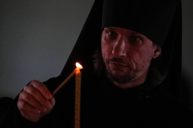 MOSCOW, RUSSIA - MARCH 20, 2020: A priest lights a candle during an evening service at the Vysokopetrovsky Monastery. Starting from March 18, monks conduct a religious procession and spray holy water after the evening service at the monastery amid the coronavirus pandemic. Sergei Bobylev TASS  TS0D2EE0