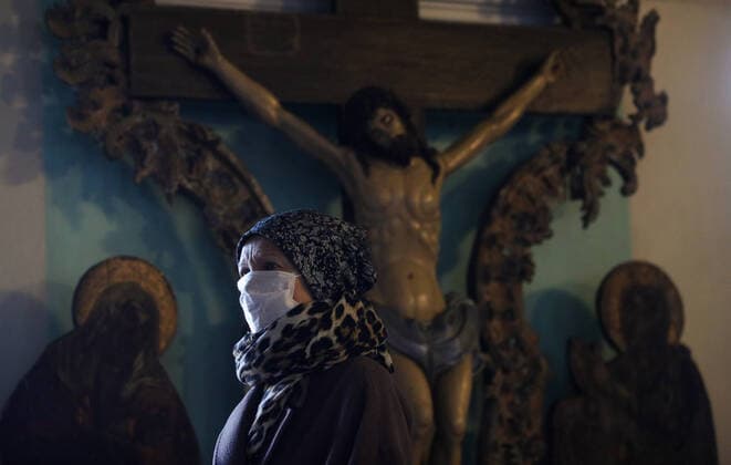 MOSCOW, RUSSIA - MARCH 20, 2020: A believer in a medical mask during an evening service at the Vysokopetrovsky Monastery. Starting from March 18, monks conduct a religious procession and spray holy water after the evening service at the monastery amid the coronavirus pandemic. Sergei Bobylev TASS  TS0D2EEA