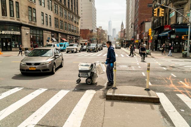 New York during the COVID-19 pandemic A masked USPS mail carrier crosses Sixth Avenue in New York on Friday, March 20, 2020. (  RichardxB.xLevine