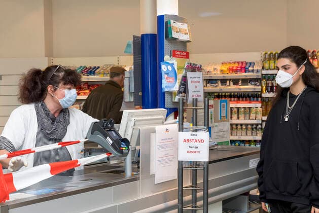 Wuerzburg, DM, 20 03 2020, Coronavirus Shopping in times Coronas picture View into a dm branch in downtown Würzburg on Friday To protect herself, the saleswoman sits behind a barrier tape at the cash desk and has a protective mask on Bavaria, Coronavirus, COVID 19, Germany, shopping, retail, Franconia, disaster, consumption, diseases, Mainfranken, protection, protective measures, supermarket, precaution, W Copyright: HMBxMediax xPattyxVarasano