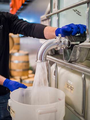 March 20, 2020, Des Moines, Iowa, U.S: GREG BIAGI, the distiller at the Foundry, a Des Moines distiller, pours hand sanitizer into a 5 gallon jug. The distillery suspended its distilling operations to make hand sanitizer this week. They distributed it free to people who came to their building. On Friday thousands of people came to get some. There line was more than one mile long. On Friday morning, 20 March, Iowa reported 45 confirmed cases of the Coronavirus. Restaurants, bars, movie theaters, places that draw crowds are closed for at least 30 days. There are no shelter in place orders in effect anywhere in Iowa but people are being encouraged to practice social distancing and many businesses are requiring or encouraging employees to telecommute. Des Moines U.S. - ZUMAk94_ 20200320_zaf_k94_011 Copyright: xJackxKurtzx
