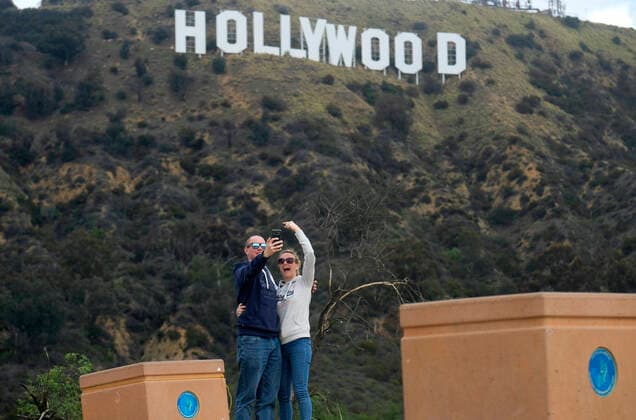 March 20, 2020, Los Angeles, California, U.S: People take pictures of the Hollywood Sign on Friday. California Gov. Gavin Newsom issued a statewide stay-at-home order Thursday for residents to venture outside only for essential jobs, errands and some exercise, due to coronavirus concerns. Los Angeles USA - ZUMAc68_ 20200320_zaf_c68_035 Copyright: xRingoxChiux