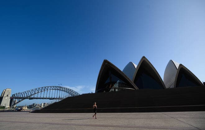 CORONAVIRUS AUSTRALIA, A woman walking in front of a nearly deserted Sydney Opera House, Sydney, Saturday, March 21, 2020. Sydney is seeing a dramatic reduction in people on the streets as people are asked to enact social distancing and self isolation in order to prevent the spread of Covid-19. ( NO ARCHIVING, EDITORIAL USE ONLY, NO USE IN BOOKS WITHOUT CONSENT SYDNEY NSW AUSTRALIA  Copyright: xJAMESxGOURLEYx 20200321001458535403