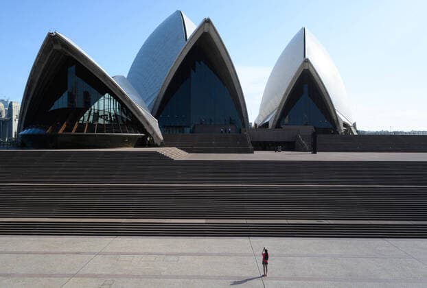 CORONAVIRUS AUSTRALIA, A lone woman takes a photograph of the Sydney Opera House, Sydney, Saturday, March 21, 2020. Sydney is seeing a dramatic reduction in people on the streets as people are asked to enact social distancing and self isolation in order to prevent the spread of Covid-19. ( NO ARCHIVING, EDITORIAL USE ONLY, NO USE IN BOOKS WITHOUT CONSENT SYDNEY NSW AUSTRALIA  Copyright: xJAMESxGOURLEYx 20200321001458535783