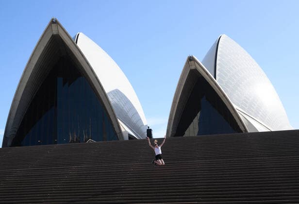 CORONAVIRUS AUSTRALIA, A lone tourist jumps on the steps of the Sydney Opera House, Sydney, Saturday, March 21, 2020. Sydney is seeing a dramatic reduction in people on the streets as people are asked to enact social distancing and self isolation in order to prevent the spread of Covid-19. ( NO ARCHIVING, EDITORIAL USE ONLY, NO USE IN BOOKS WITHOUT CONSENT SYDNEY NSW AUSTRALIA  Copyright: xJAMESxGOURLEYx 20200321001458535864
