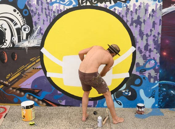 BONDI BEACH CORONAVIRUS CLOSURE, Street artist NOTNOTCAMSCOTT painting a mural whilst wearing a protective face mask depicting a person wearing a protective face mask on Bondi Beach Promenade in Sydney, Saturday, March 21, 2020. Beachgoers drew condemnation yesterday when tens of thousands of people flouted social distancing rules, which have been put in place in an effort to limit the spread of COVID-19. ( NO ARCHIVING, EDITORIAL USE ONLY, NO USE IN BOOKS WITHOUT CONSENT SYDNEY NSW AUSTRALIA  Copyright: xJAMESxGOURLEYx 20200321001458565317