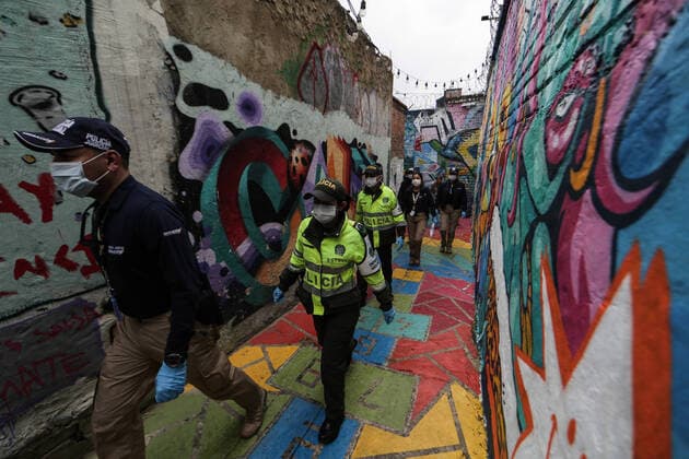 (200321) -- BOGOTA, March 21, 2020 (Xinhua) -- Policemen patrol an alley in Bogota, Colombia, March 20, 2020. The Colombian capital of Bogota began on Friday the mandatory isolation drill decreed by mayor Claudia Lopez in order to prepare for a quarantine aimed at containing the COVID-19 pandemic. The mandatory isolation drill in the Colombian capital, home to more than seven million people and where 56 of Colombia s 145 cases of COVID-19 have been confirmed, will remain in effect until midnight on March 23. (Photo by Jhon Paz Xinhua) COLOMBIA-BOGOTA-MANDATORY ISOLATION 