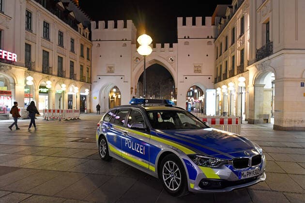 Theme picture Corona pandemic Bavaria decides to restrict the exit of police, policemen, police car at Stachus Karlsplatz in Munich, pedestrian zone Neuhauserstrasse on the late evening before the curfew is imposed on 20 03 2020 Some people are still on the road