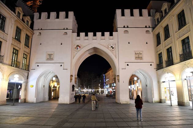 Theme picture Corona pandemic Bavaria decides to restrict the exit from Stachus Karlsplatz in Munich with a view into Neuhauser Strasse, pedestrian zone on the late evening before the curfew is imposed on 20 03 2020 Some pedestrians and people are still on the move