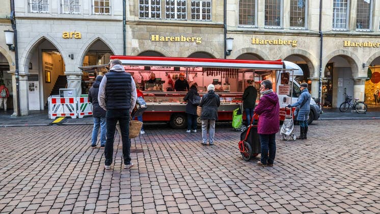 DEU, Germany, North Rhine-Westphalia, Münster, 21 03 2020 At the beginning of the 20th century the weekly market in Münster had moved from Prinzipalmarkt to Domplatz Due to the risk of corona infection, the weekly market was equalised to create open spaces between stands for waiting customers Some market stands are therefore located at Prinzipalmarkt and Michaelisplatz Stands are set up Distan