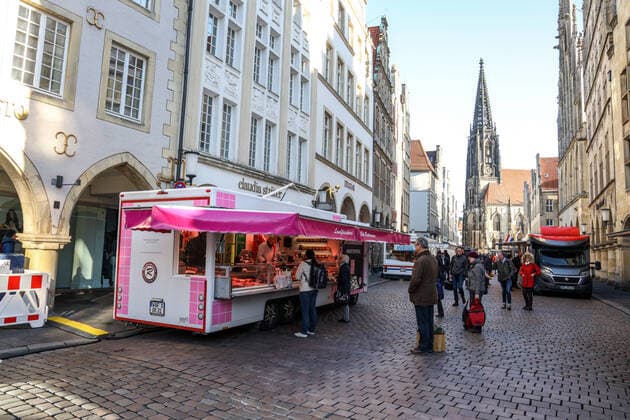 DEU, Germany, North Rhine-Westphalia, Münster, 21 03 2020 At the beginning of the 20th century the weekly market in Münster had moved from Prinzipalmarkt to Domplatz Due to the risk of corona infection, the weekly market was equalised to create open spaces between stands for waiting customers Some market stands are therefore located at Prinzipalmarkt and Michaelisplatz Stands are set up Distan