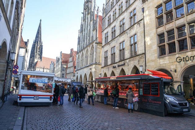 DEU, Germany, North Rhine-Westphalia, Münster, 21 03 2020 At the beginning of the 20th century the weekly market in Münster had moved from Prinzipalmarkt to Domplatz Due to the risk of corona infection, the weekly market was equalised to create open spaces between stands for waiting customers Some market stands are therefore located at Prinzipalmarkt and Michaelisplatz Stands are set up Distan