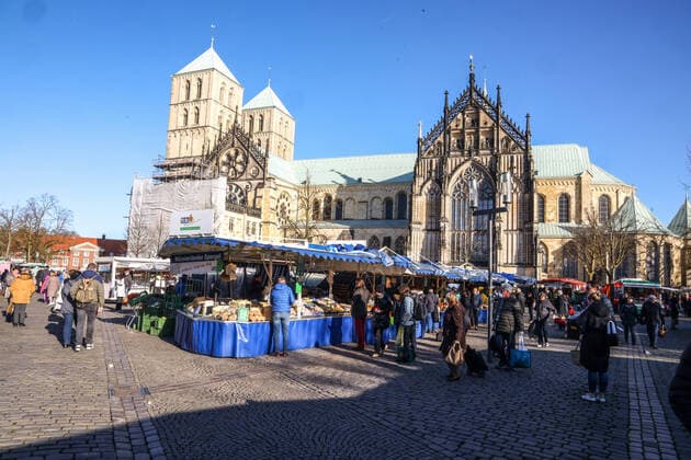 DEU, Germany, North Rhine-Westphalia, Münster, 21 03 2020 At the beginning of the 20th century the weekly market in Münster had moved from Prinzipalmarkt to Domplatz Due to the risk of corona infection, the weekly market was equalised to create open spaces between stands for waiting customers Some market stands are therefore located at Prinzipalmarkt and Michaelisplatz Stands are set up Distan