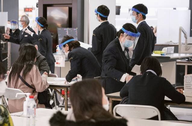 Two-week quarantine in Japan for travelers from Europe Arriving passengers (in seats) fill out forms as quarantine officials watch at Narita airport near Tokyo on March 21, 2020. Travelers from Europe, Egypt and Iran are required to self-quarantine for 14 days after their arrival as Japan attempts to contain the spread of the new coronavirus. 