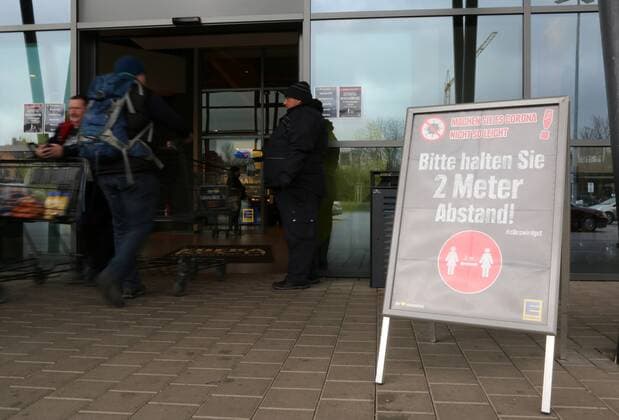 Corona 21 03 2020 , Erfurt, EDEKA Markt, a sign at the entrance with the note Please keep a distance of 2 meters between you and a person with a shopping cart entering the market, at the entrance is Security