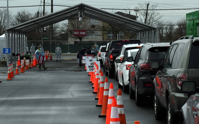 Vehicles line up for sample collection at the drive-through COVID-19 Mobile Testing Center located at the South Beach Behavioral Center, Staten Island, New York, on March 19, 2020. Members of the New York Army and Air National Guard provide additional administrative and medical support to the medical professional during Operation COVID-19.  WAX2020032103 PATRICKxCORDOVA