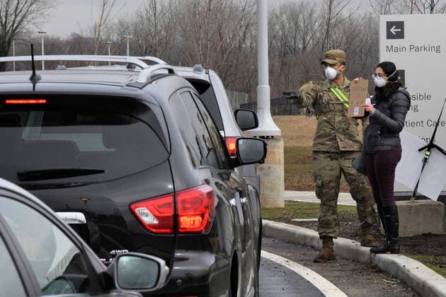A New York Army National Guard Soldier and a civilian worker direct traffic at a drive-through COVID-19 Mobile Testing Center at the South Beach Behavioral Center, Staten Island, New York, on March 19, 2020. Currently, the test location is only sampling individuals with an appointment. Members of the New York Army and Air National Guard from a have been activated under Operation COVID-19 to support, state, and local efforts.  WAX2020032104 PATRICKxCORDOVA