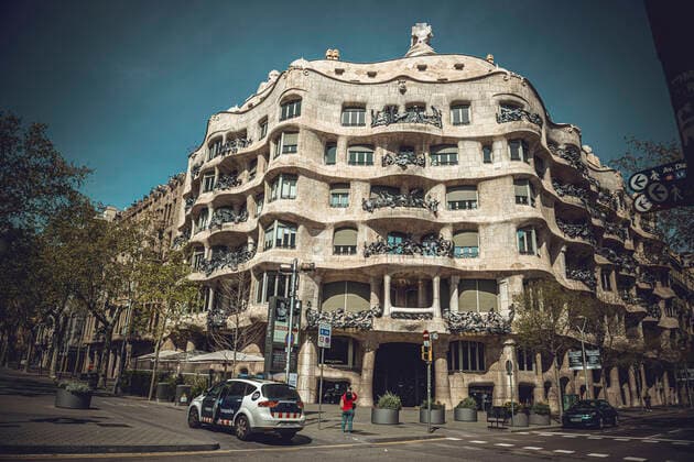 March 21, 2020: Catalan police officers approach a woman taking a photo of Barcelona s La Pedrera by Gaudi at the end of the first week of a nationwide lockdown due to the continuous spread of the COVID-19 virus. Spain has entered the worst phase of this disease so far counting more than thousand deaths with no end at sight. - ZUMAo105 20200321_zap_o105_003 Copyright: xMatthiasxOesterlex