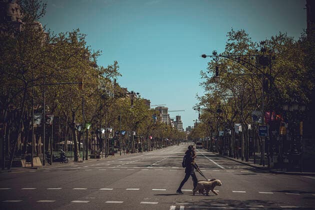 March 21, 2020: A woman crosses the usually bustling Passeig de Gracia as she walks her dogs at the end of the first week of a nationwide lockdown due to the continuous spread of the COVID-19 virus. Spain has entered the worst phase of this disease so far counting more than thousand deaths with no end at sight. - ZUMAo105 20200321_zap_o105_002 Copyright: xMatthiasxOesterlex