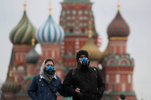 MOSCOW, RUSSIA - MARCH 21, 2020: A young couple in respirators walk in Red Square near St Basil s Cathedral. As of 21 March 2020, Russia has confirmed more than 250 cases of the novel coronavirus, with more than 130 cases in Moscow. Sergei Savostyanov TASS  TS0D3002