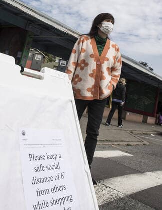 A sign asks shoppers at Farmers Market on Alemany Street to practice social distancing while waiting in line for produce in San Francisco on Saturday, March 21, 2020. All of California is ordered to shelter in place.  SXP2020032108 TERRYxSCHMITT