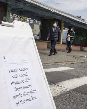 A sign asks shoppers at Farmers Market on Alemany Street to practice social distancing while waiting in line for produce in San Francisco on Saturday, March 21, 2020. All of California is ordered to shelter in place.  SXP2020032109 TERRYxSCHMITT