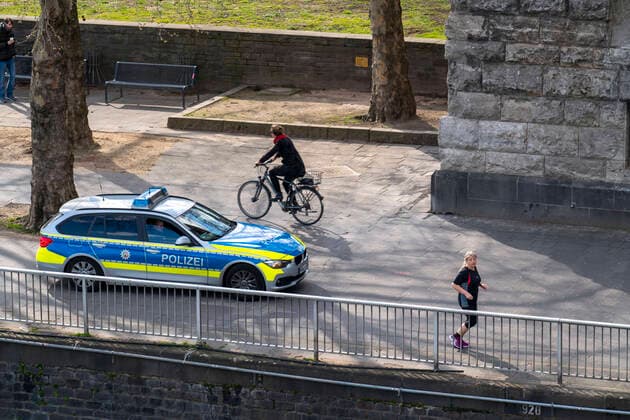 Effects of the coronavirus crisis, empty shopping street, police patrol car, Rheinufer Heinrich Böll Platz, in Cologne, Germany, corona crisis