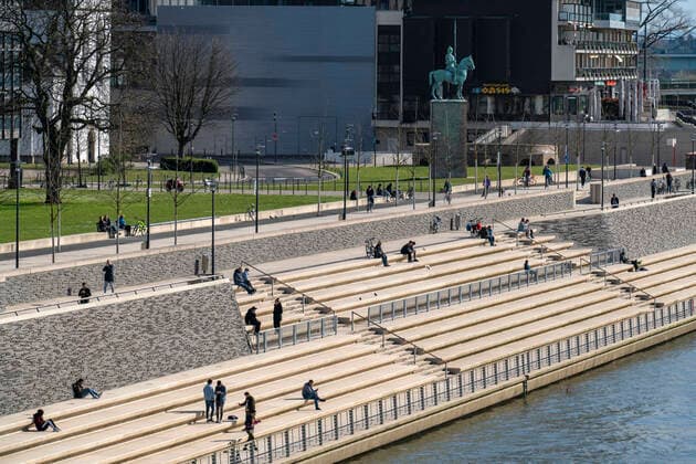 Effects of the coronavirus crisis, Rhine promenade, Rhine boulevard, on the Deutzer Ufer, few people with much distance between each other in the spring sun, Cologne, Germany, corona crisis