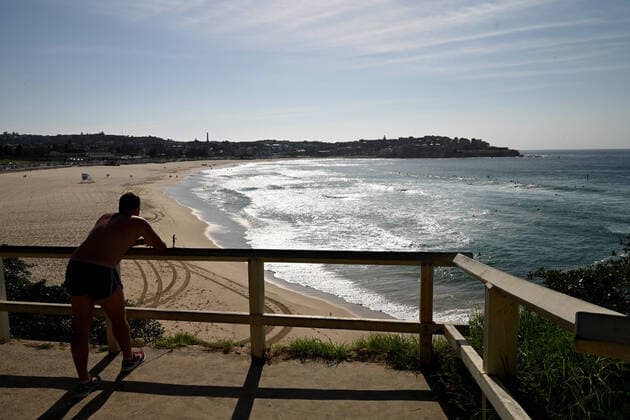 BONDI BEACH CORONAVIRUS CLOSURE, A man looks out at a closed at Bondi Beach in Sydney, Sunday, March 22, 2020. Beachgoers drew condemnation on Friday when tens of thousands of people flouted social distancing rules, which have been put in place in an effort to limit the spread of COVID-19. ( NO ARCHIVING, EDITORIAL USE ONLY, NO USE IN BOOKS WITHOUT CONSENT SYDNEY NSW AUSTRALIA  Copyright: xJOELxCARRETTx 20200322001458672622