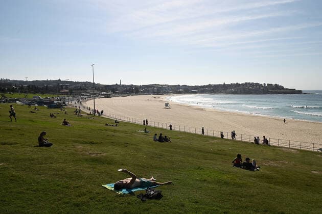 BONDI BEACH CORONAVIRUS CLOSURE, Beachgoers seen seeing their distance on the grass at Bondi Beach in Sydney, Sunday, March 22, 2020. Beachgoers drew condemnation on Friday when tens of thousands of people flouted social distancing rules, which have been put in place in an effort to limit the spread of COVID-19. ( NO ARCHIVING, EDITORIAL USE ONLY, NO USE IN BOOKS WITHOUT CONSENT SYDNEY NSW AUSTRALIA  Copyright: xJOELxCARRETTx 20200322001458673991