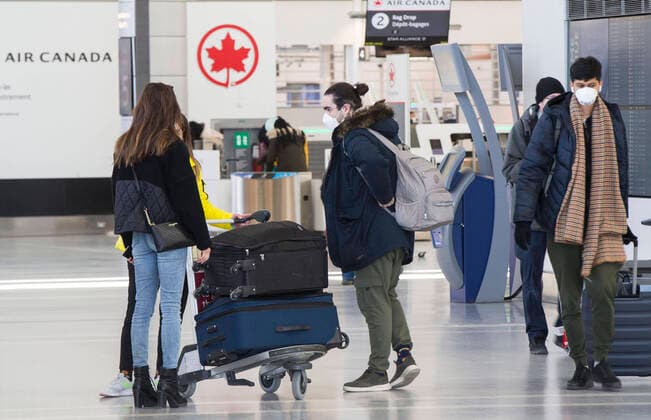 (200322) -- TORONTO, March 22, 2020 -- Travellers prepare to check in at the Terminal 1 of Pearson International Airport in Toronto, Canada, March 21, 2020. Air Canada is laying off more than 5,000 flight attendants as the country s largest airline cuts routes and parks planes due to the COVID-19 pandemic. The temporary layoffs will take effect by April. (Photo by Xinhua) CANADA-TORONTO-COVID-19-AIR CANADA-LAY OFF ZouxZheng 
